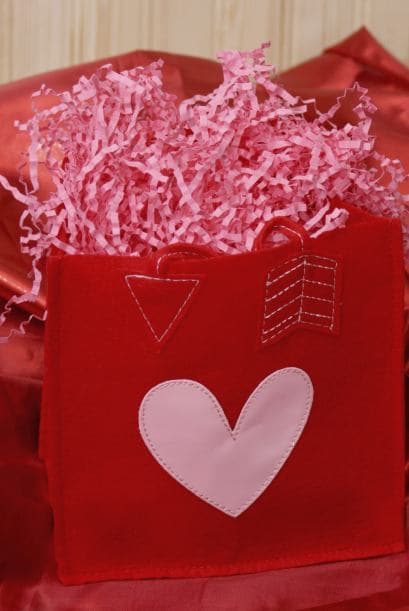 Bolsa para caramelos. Para esto, quizá los niños pequeños necesiten tu ayuda. Se requieren pocos materiales: fieltro rojo, pegamento para tela, aguja y cinta roja. Pueden decorarla con lentejuelas, piedritas o con lo que quieran adornarla.