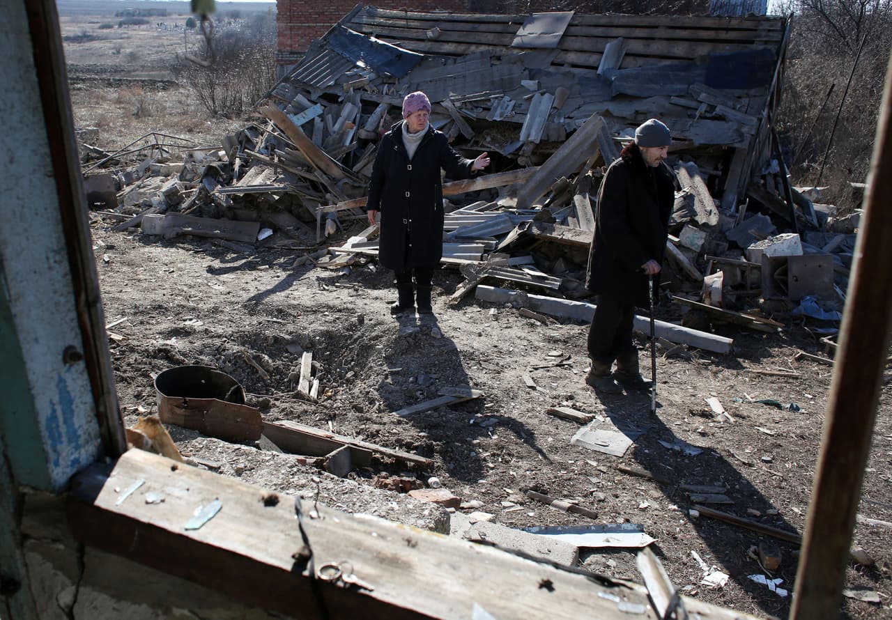 Los residentes frente a su casa destruida después de un bombardeo en Donetsk, este 20 de febrero de 2022.
<b>La resolución del conflicto, prevista en los acuerdos de Minsk de 2015, está en un punto muerto, ya que el gobierno ucraniano y los separatistas se acusan de no respetarlos. </b>
<br>
<br>Aunque se instauraron varias treguas, quedaron obsoletas por las repetidas violaciones de las partes en conflicto.