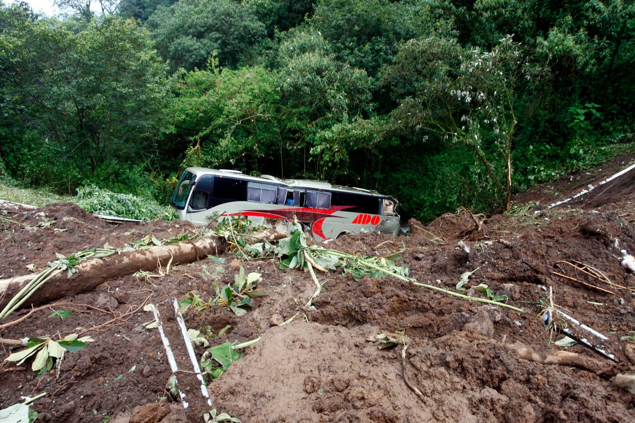 Un autobús de pasajeros queda varado en medio de la zona destruida de Tlaola, Puebla.
