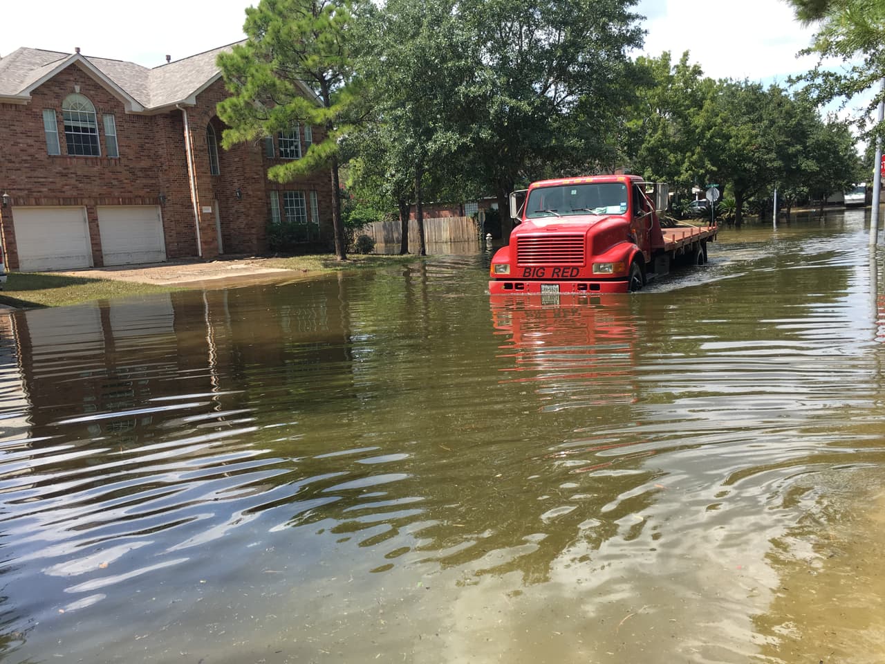 El conductor de este camión, que se abría paso por las calles inundadas, logró auxiliar a decenas de residentes de Canyon Gate que regresaron al vecindario después de las inundaciones.