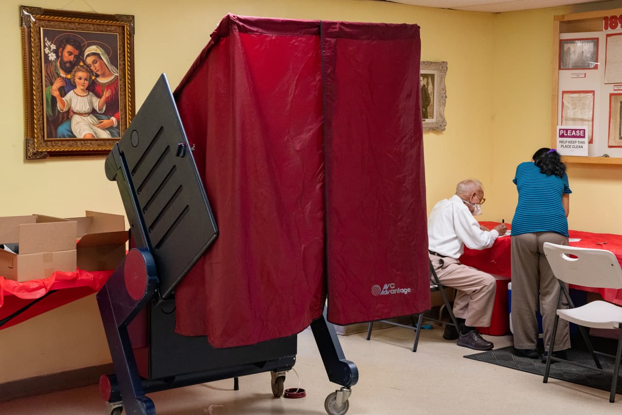 Un trabajador electoral ayuda a un votante a emitir su voto en el colegio electoral de Saint Aloysius en Jersey City, Nueva Jersey. El popular senador Cory Booker está en la papeleta en busca de su segundo mandato. Se enfrenta a Larry Hamm, un activista local que organizó una protesta pacífica contra la brutalidad policial en Newark en mayo que atrajo a miles.