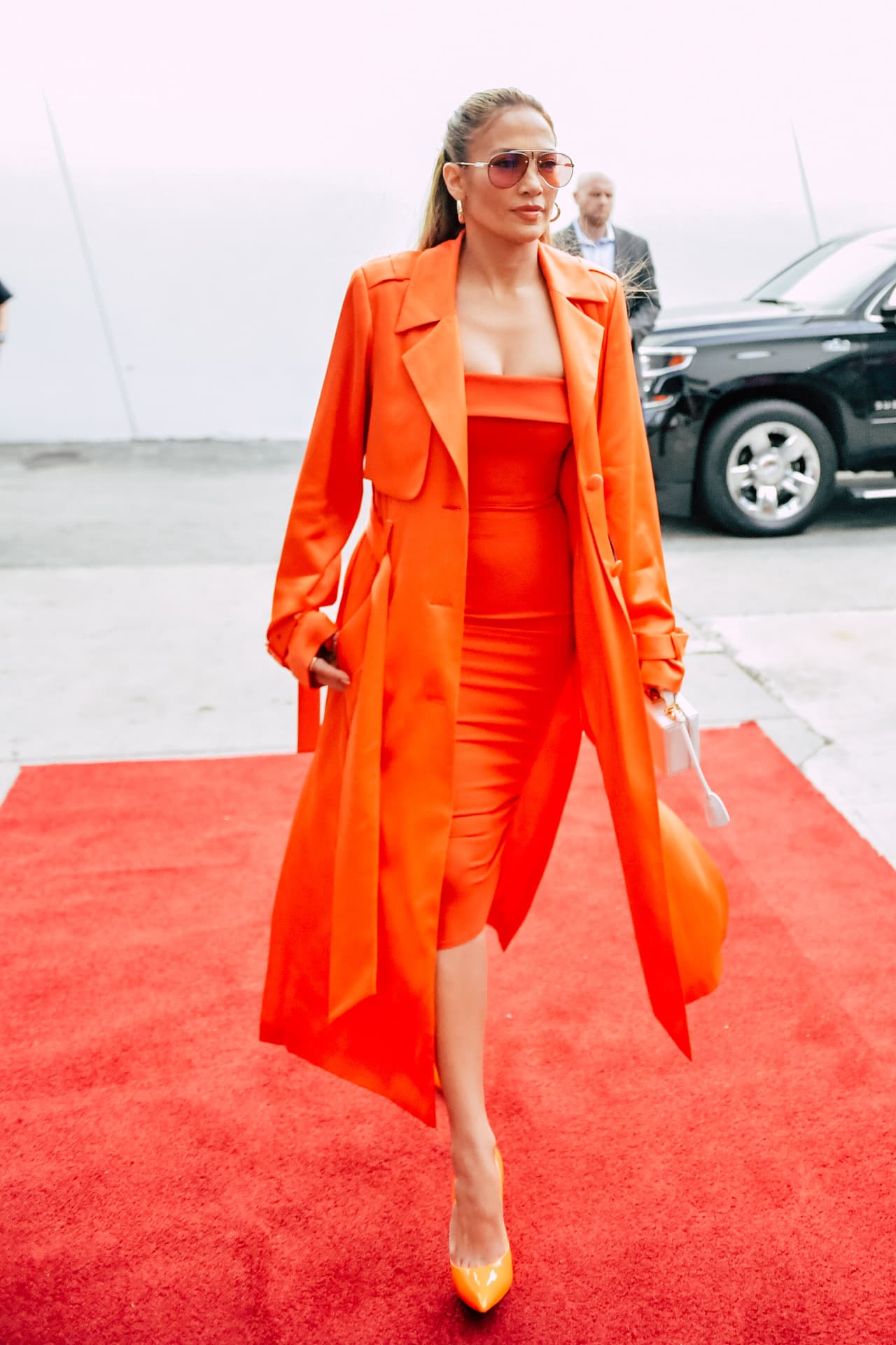 Sobre el vestido llevaba una gabardina satinada en el mismo tono, ligeramente más larga que el vestido.