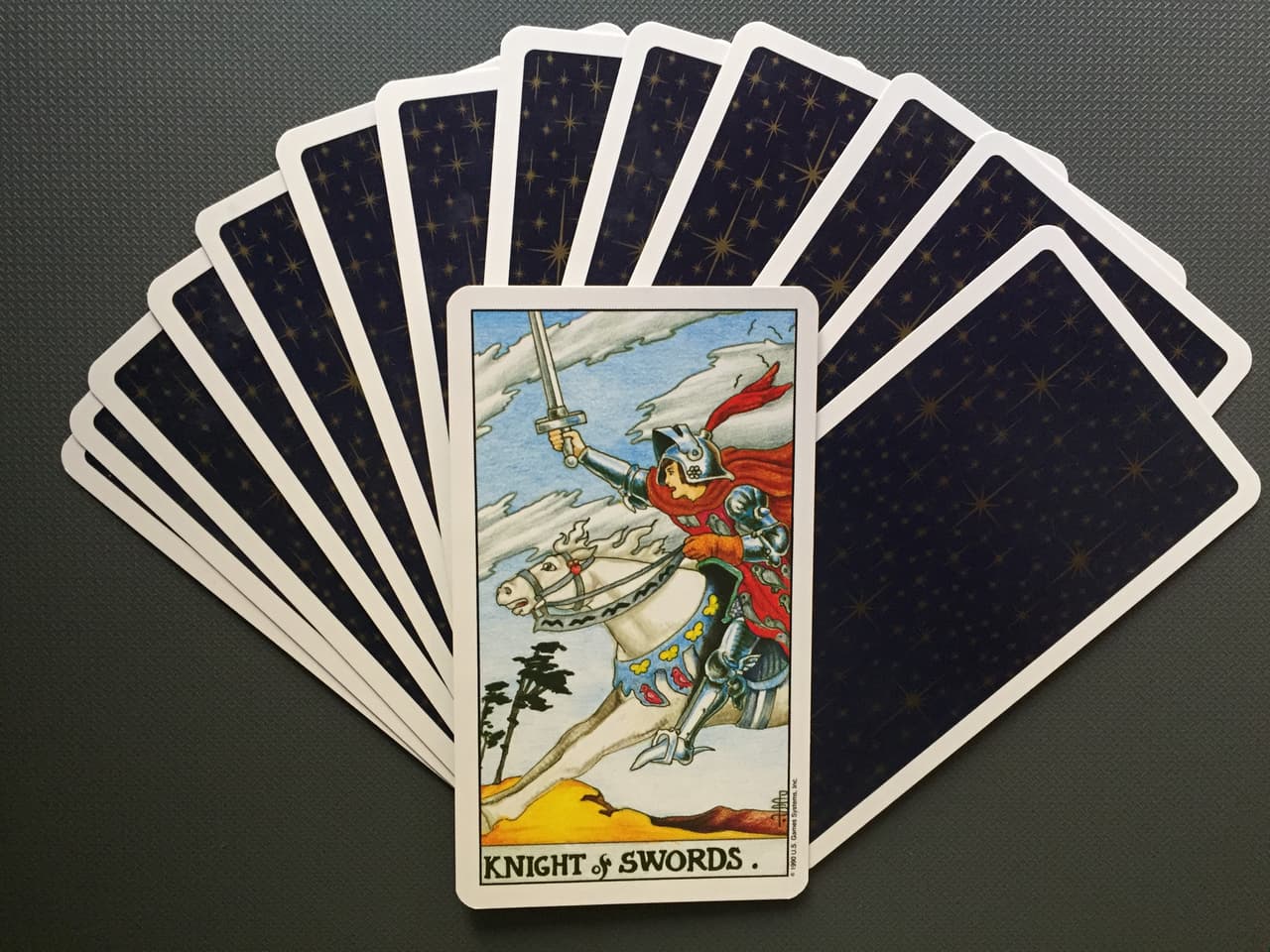 La carta más representativa del caballero de espadas muestra a un joven con armadura montando en un poderoso caballo blanco, listo para ir a una batalla en la distancia. El animal blanco simboliza la pureza de la energía intelectual y mental del jinete.