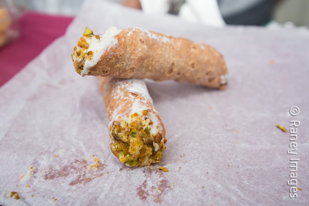 O participar en la competencia de comer cannolis.