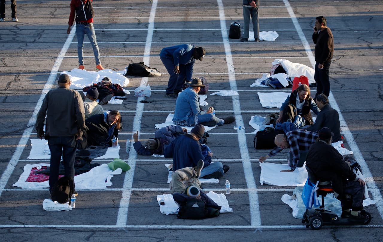 La gente se prepara para dormir en áreas marcadas con cajas pintadas en el suelo de un estacionamiento en un campamento improvisado para personas sin hogar el lunes 30 de marzo de 2020 en Las Vegas.