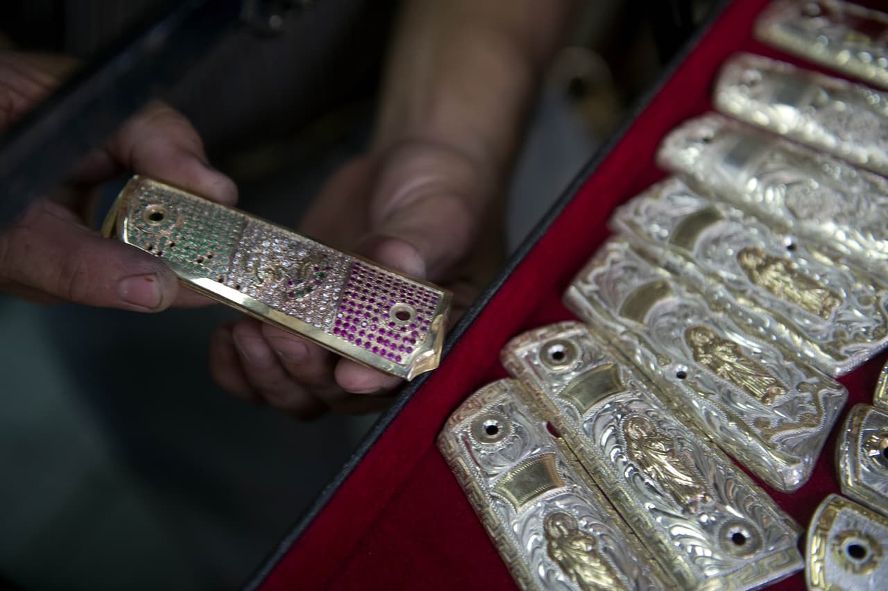 En Sinaloa, algunos joyeros tienen en muestra las cachas de las pistolas "enchuladas" al gusto del cliente. En esta fotografía se muestran unas cubiertas de oro, diamantes, esmeraldas y rubíes formando la bandera mexicana. 
<br>