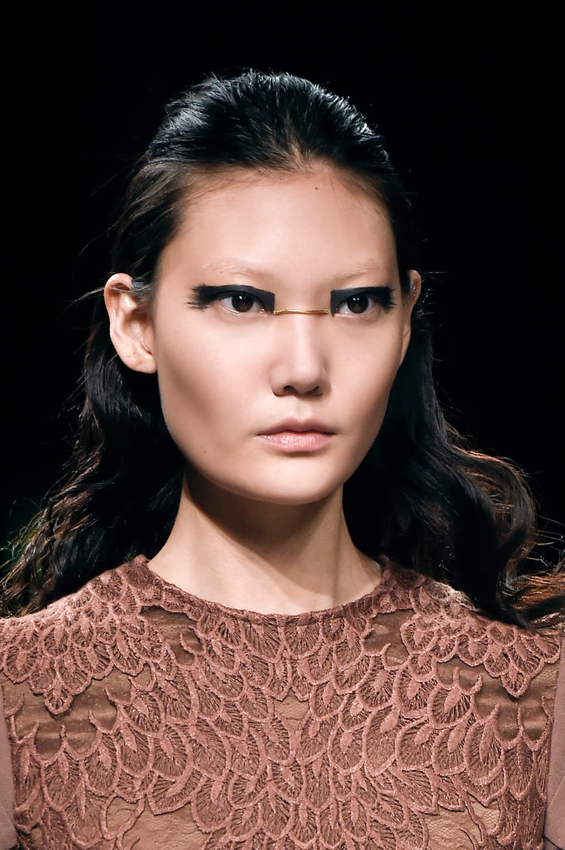 Con ayuda de un delineador líquido traza una forma rectangular en el párpado que vaya del lagrimal al rabillo, tal como se vio en el desfile de 
<a href="http://www.vogue.it/en/shows/show/collections-fall-winter-2016-17/aigner">Aigner</a>. Al finalizar, realiza trazos imperfectos. Si prefieres usar una sombra en crema no olvides sellarla con polvo, para evitar que se corra. Si no quieres pegar un listón sobre la piel, une ambos lagrimales con un trazo dorado. Tendrás un 'efecto antifaz' de súperhéroe 
<i>fashionista</i> ideal para tu disfraz. 
<br>