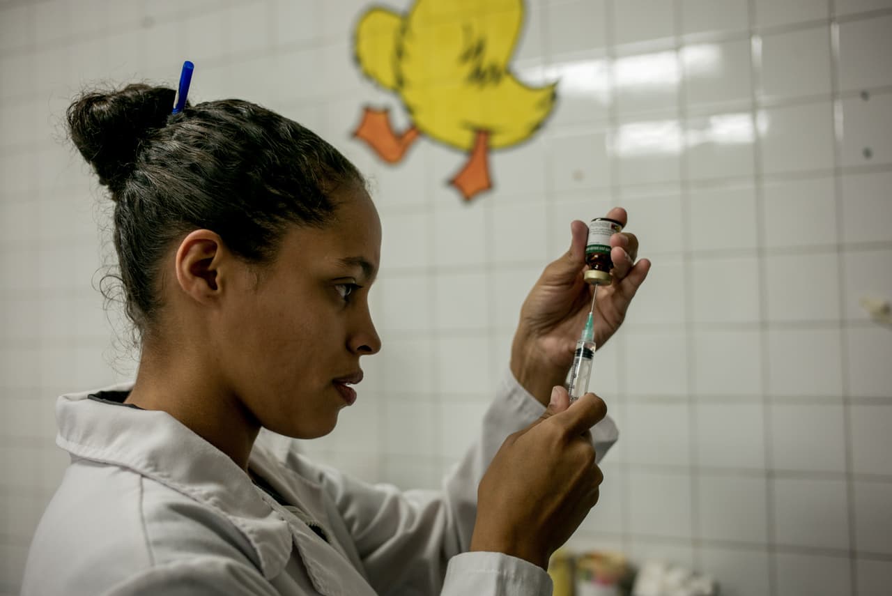 Una médico comunitaria prepara la dosis de medicina que necesita un pequeño paciente. Un especialista con dos posgrados gana en este hospital el equivalente a nueve dólares mensuales.