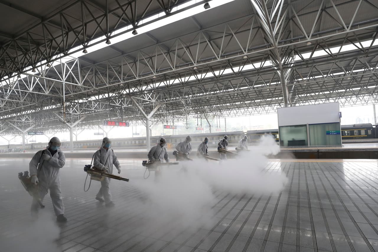 Operarios de sanidad desinfectan una estación de tren en la provincia de Hubei, en China, el 24 de marzo de 2020.