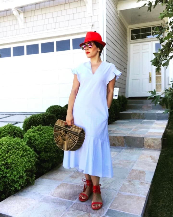 Aquí la vemos vistiendo un modelito blanco con zapatos y sombrero en color rojo.