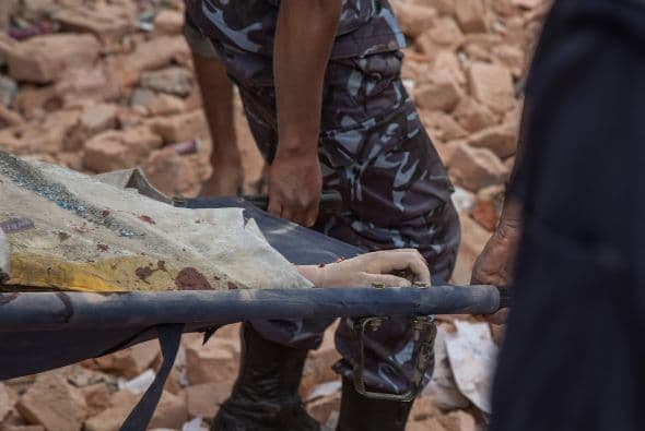 Trabajadores de rescate se llevan los cuerpos de las víctimas de entre los escombros de las edificaciones destruidas.