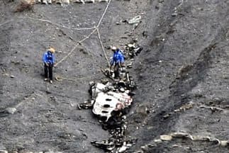 Dos rescatistas junto a una de las partes del fuselaje del Airbus A320 de Germanwings que se estrelló en los Alpes franceses.