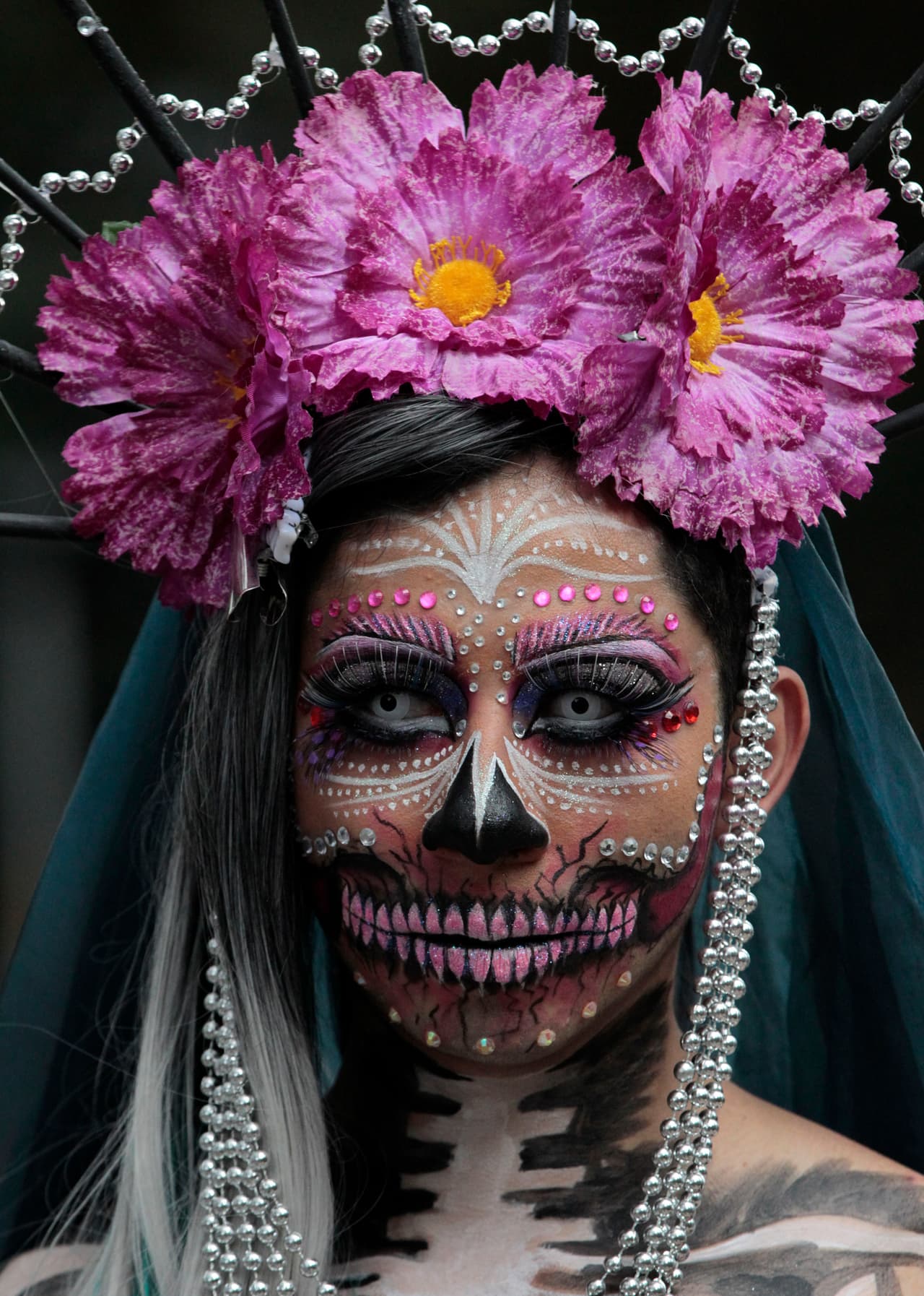 Una catrina, con flores moradas en la cabeza. Como ella, decenas de carros alegóricos, inflables, marionetas y catrinas, evocaron en un kilómetro de longitud el tránsito hacia la muerte.