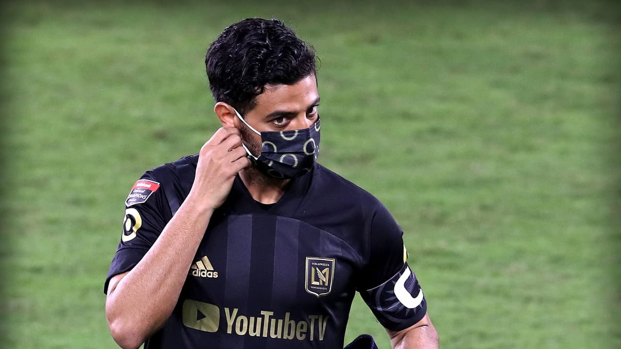 Carlos Vela de LAFC quitándose el cubrebocas en el campo.