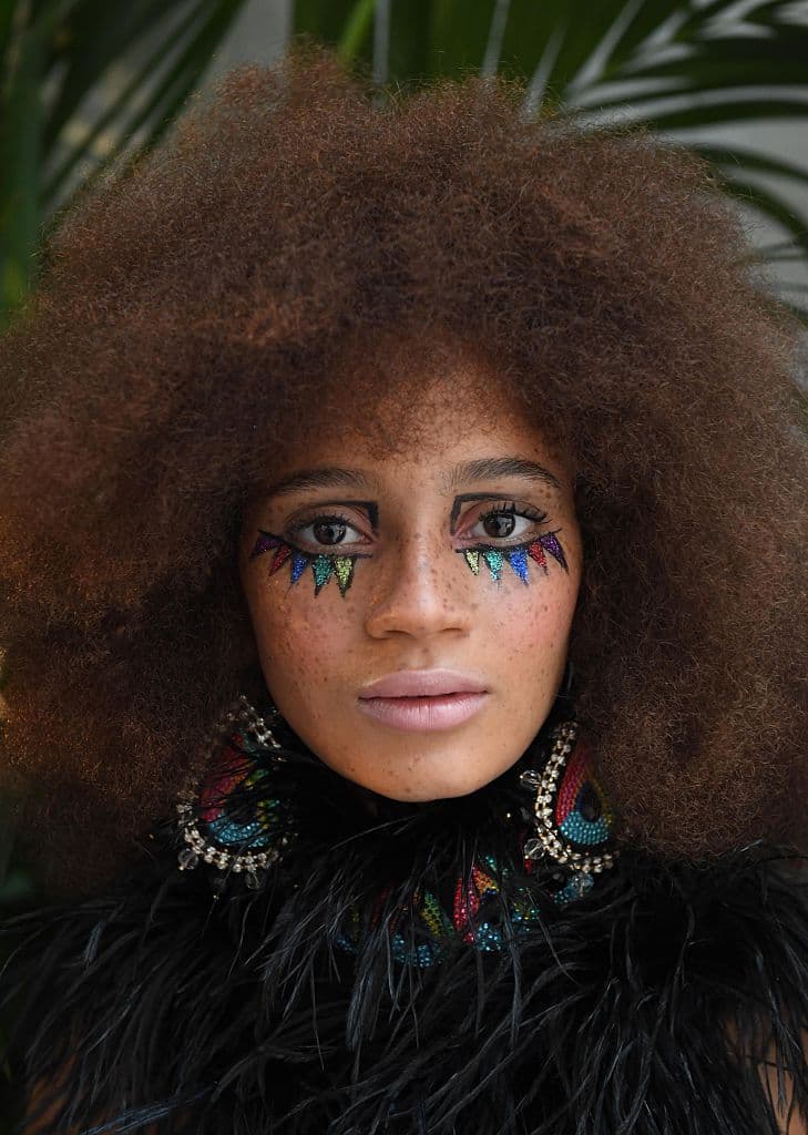 Los maquillajes de la presentación de 
<a href="https://www.sophiawebster.com/">Sophia Webster</a> no fueron iguales. Pero una constante entre los diferentes look, fue la piel ligera, con lipstick en tono nude y un poco de blush. Banderas de colores con acabado metálicos se apoderaron de la zona de la ojera de esta modelo. El trazo preciso con delineador negro delimitaba el área del que pareciera un decorado festivo.
<br>