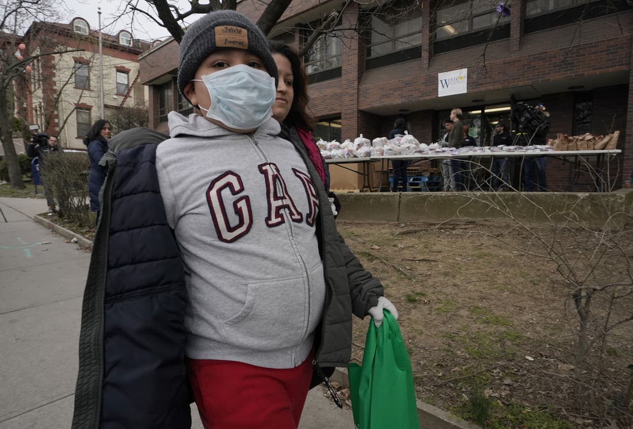 Selvin Jiménez, de 10 años, toma una de las raciones de comida entregadas por la Guardia Nacional en New Rochelle. Se han empaquetado unas 3,000 comidas que están siendo distribuidas por los soldados y una veintena de voluntarios, explicó Bonnet.