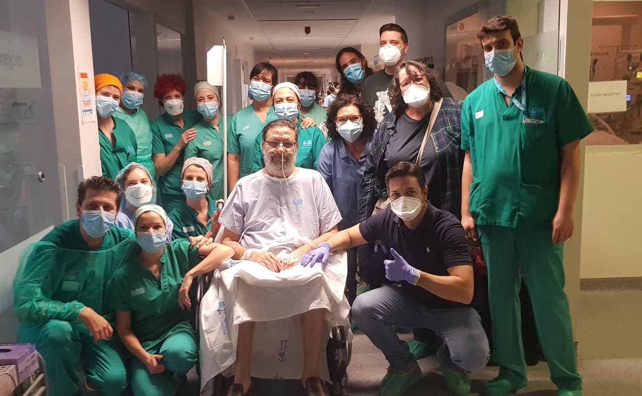 Gabriel Heras (arrodillado, abajo a la izquierda) junto a un paciente de covid-19 y el resto del equipo de la UCI del Hospital de Torrejón (Madrid).