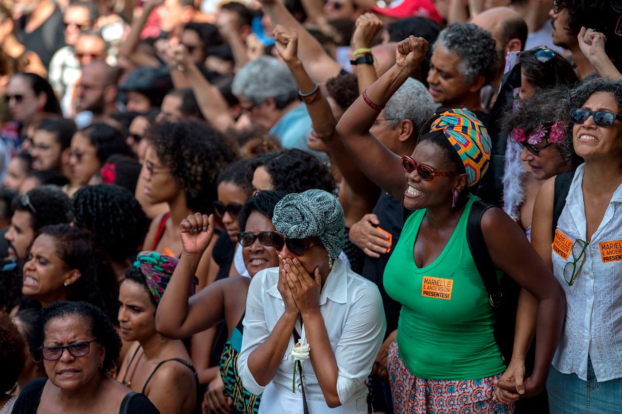 Mourners attend the funeral of slain Brazilian councilwoman and activist Marielle Franco, outside Rio de Janeiro's Municipal Chamber in Brazil on March 15, 2018. Brazilians mourned Thursday for a Rio de Janeiro councilwoman and outspoken critic of police brutality who was shot in the city center in an assassination-style killing on the eve. Some 1,000 people stood under the tropical sun outside City Hall to greet the coffin of Marielle Franco, 38, who was murdered late Wednesday. / AFP PHOTO / Mauro Pimentel (Photo credit should read MAURO PIMENTEL/AFP/Getty Images)