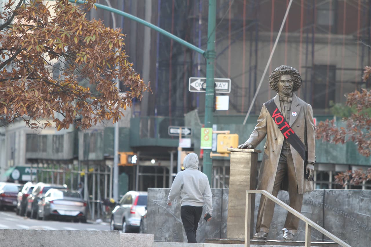 La estatua del abolicionista Frederick Douglas localizada en la esquina de bulevar Fedrerick Douglas y la calle 110 Oeste en Manhattan. Está mañana se vió adornada con un calcomanía que dice "vota" y bandana.