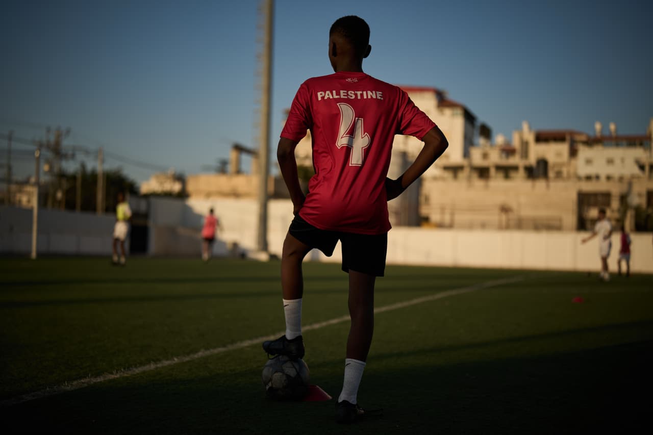 Un joven de una academia local, vestido con la camiseta de la selección nacional de fútbol de Palestina, participa en una sesión de entrenamiento en el estadio Jamal Ghanem, en la ciudad de Tulkarem, Cisjordania, el jueves 4 de junio de 2026. (Foto AP/Leo Correa)