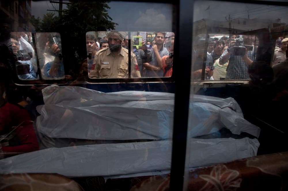 Una ambulancia con uno de los cadáveres encontrados en la casa donde murieron 11 miembros de la misma familia.
