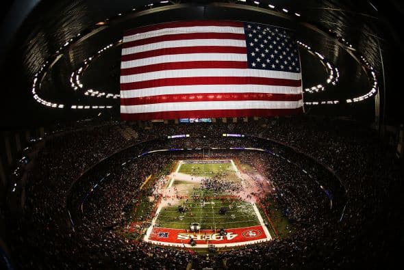 La gran fiesta deportiva del año en Estados Unidos, el Super Bowl de la Liga Nacional de Fútbol Americano (NFL), en su cuadragésima séptima edición, ya forma parte de la historia con los Ravens de Baltimore como nuevos campeones al vencer por 34-31 a los 49ers de San Francisco. Los pronósticos se cumplieron, los Ravens llegaron al Mercedes-Benz Super Dome de Nueva Orleans con el mejor mariscal de campo del momento, Joe Flacco, y la mejor defensa de la NFL, ambos factores se hicieron presentes en los momentos decisivos que hicieron posible el triunfo y el conseguir el segundo trofeo Vince Lombardi en la historia de la franquicia de Baltimore. Flacco, de 28 años, fue el líder perfecto en la primera parte al conseguir tres pases de anotación, que lo dejaron como el sexto mariscal que lo consigue en la historia del Super Bowl y una ventaja parcial de 21-6 al descanso que sería decisiva. El safety Ed Reed, nativo de New Orleans, empataría la mejor marca de la fase final de la NFL con nueve robos aéreos, mientras que Kaepernick quedaría con la mancha de la interceptación que sufrió. Antes que se diese el ya histórico apagón, el primero en un Super Bowl, el receptor abierto Jacoby Jones también quiso entrar en los libros de las marcas al conseguir nada más comenzar el tercer periodo al regresar 108 yardas de "touchdown" una devolución de balón, la mejor de todos los tiempos. Kaepernick y los 49ers vivieron los momentos estelares del partido al conseguir 23 puntos en menos de 13 minutos, 17 fueron consecutivos. Lewis, no brilló como en el primer Super Bowl del 2001 cuando ganó el premio de Jugador Más Valioso (MVP), que esta vez le fue con todos los honores a Flacco, al completar 22 de 33 pases para 287 yardas, sin interceptaciones, pero hizo seis derribos y cuatro fueron "placajes" solitarios. Suficientes para que los Ravens lograsen el segundo trofeo Vince Lombardi en su historia y Lewis pudiese cerrar con broche de oro su legado de 17 temporadas brillantes dentro de la competición de la NFL. Mientras que la revelación de la temporada Kaepernick confirmó que es un mariscal muy especial, lleno de energía, que corre como nadie, que tiene un dinamismo único, pero que todavía no pudo emular a los legendarios Montana y Young, que lo precedieron al frente de los 49ers en los cinco Super Bowls que disputaron y que consiguieron ganar. Los jugadores de los 49er, encabezados por el corredor Frank Gore insistieron que su equipo fue mejor como conjunto que los Ravens se aprovecharon de acciones aisladas. Pero el marcador final estableció que los ganadores fueron los Ravens, por eso dos hermanos, John y Jim Harbaugh, los primeros en la historia de la NFL que dirigieron a los equipos que disputaron un título de Super Bowl, al concluir el partido fueron al encuentro y se dieron un gran abrazo.