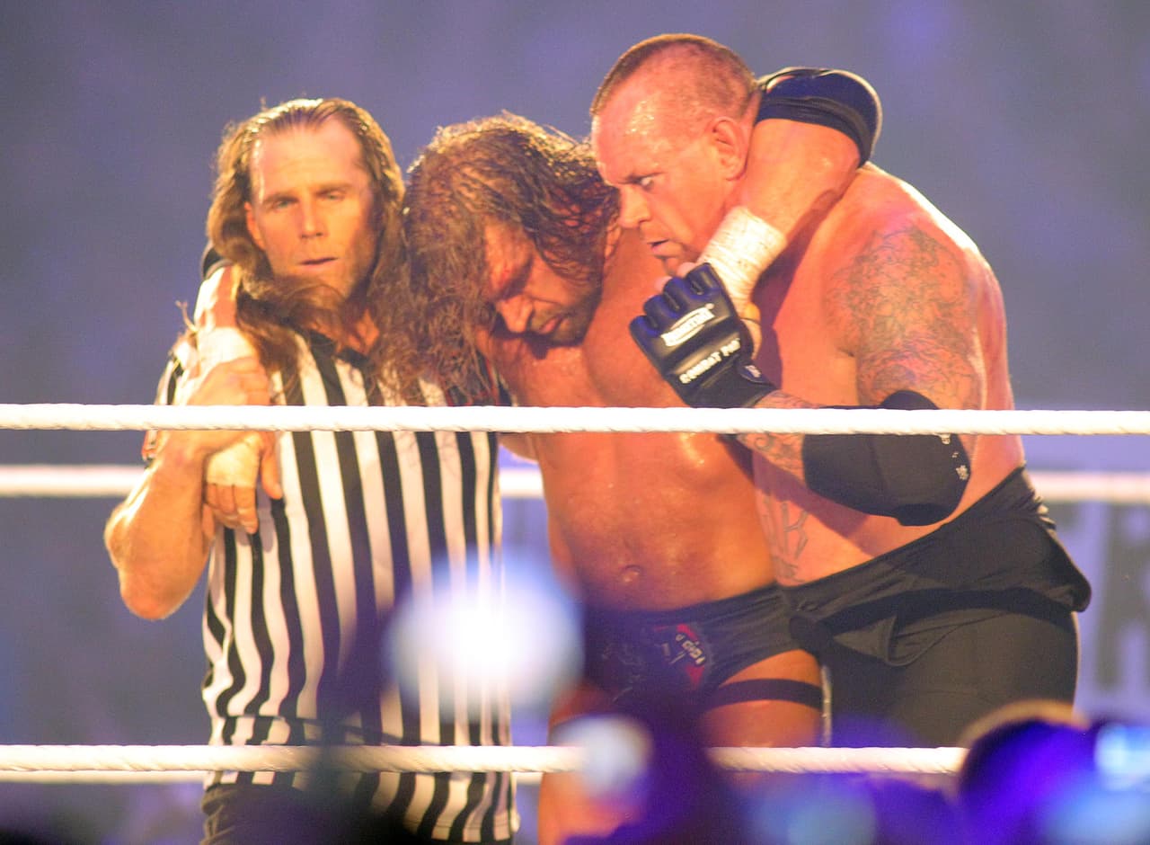 El salón de la fama, Shawn Michaels y Triple H ayudan al Undertaker a salir del ring en el WrestleMania XXVIII en 2012.