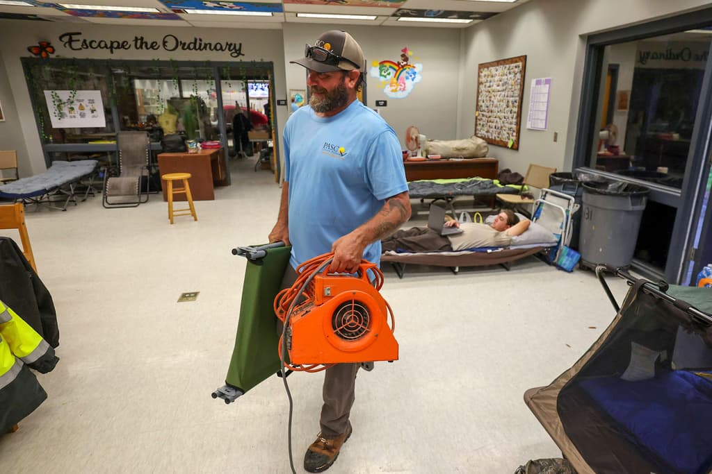<b>Listo para dormir:</b> Mike Ketchum trae equipo para prepararse para dormir en un aula en un refugio contra huracanes en River Ridge Middle/High School mientras pasa el huracán Milton, el miércoles 9 de octubre de 2024, en New Port Richey, Florida.