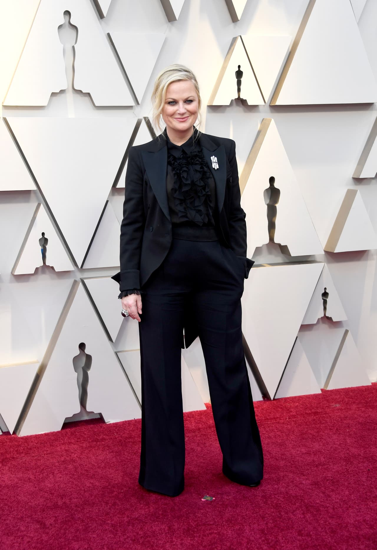 <b>Lo mejor:</b> los trajes de pantalón y los looks masculinos en la alfombra. Varias actrices eligieron magistralmente llevar esta alternativa a los vestidos de gala. Aquí Amy Ooehler con un clásico frac negro con camisa de volantes.