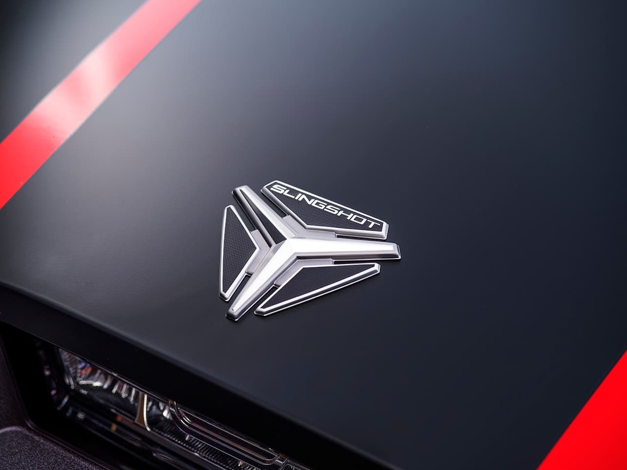 El logo del Slingshot fue inspirado por su nombre que en español significa ‘Honda’ / ‘Resortera’… las dos ruedas delanteras y una posterior.