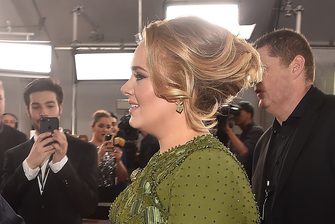Adele llega al a alfombra roja de Grammy 2017 en Los Ángeles con un elegante vestido y peinado.