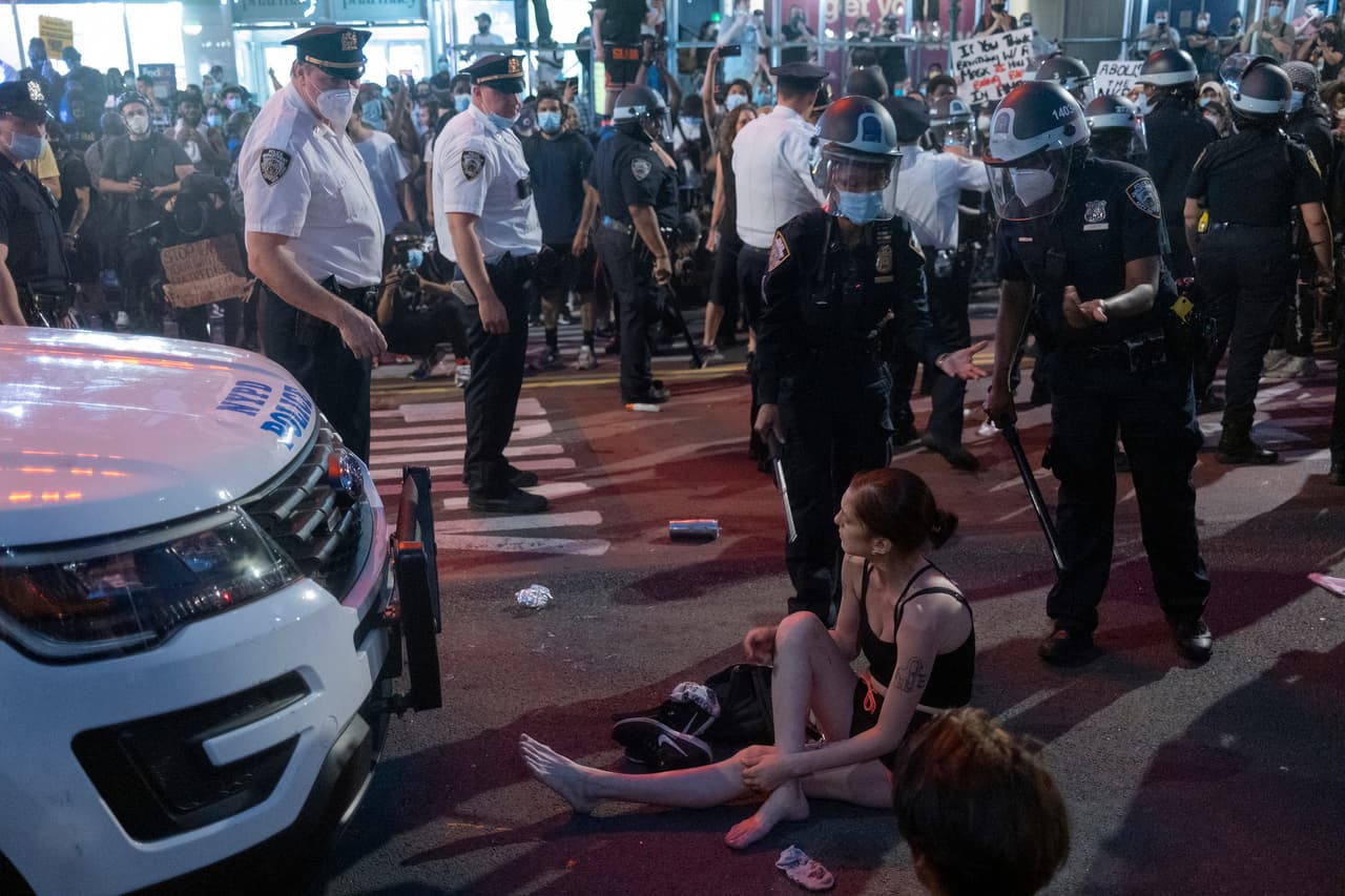 Mujer sentada en la calle enfrente de un carro de la policía durante la protesta en Union Square, Manhattan, el sábado, 30 de mayo, clamando justicia para George Floyd quien murió en Minneapolis el lunes 25 de mayo.