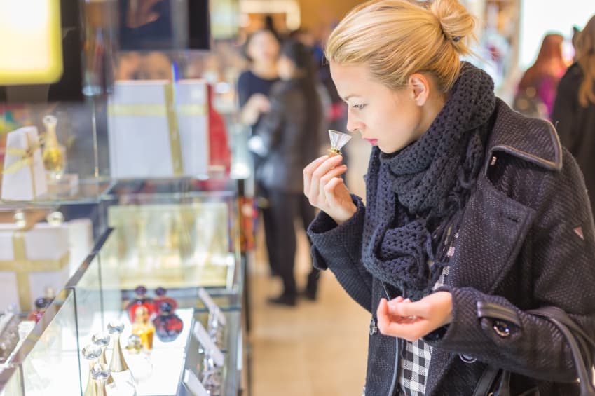 Mujer oliendo perfumes en mall