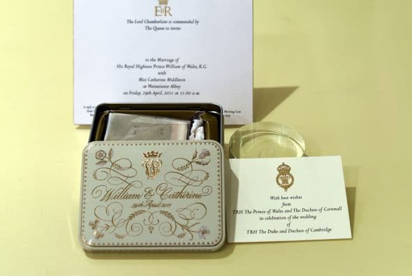 El trozo de pastel de frutas viene en una cajita metálica acompañada de una tarjeta de invitación de la reina Isabel II, aunque sin nombre.