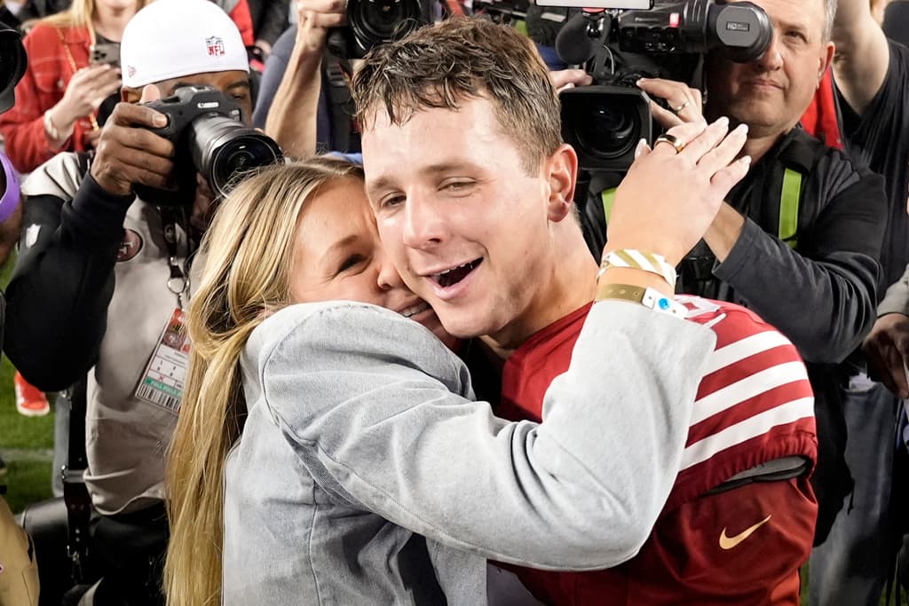 El mariscal de campo de los 49ers de San Francisco, Brock Purdy, derecha, abraza a su prometida, Jenna Brandt, después del partido de fútbol americano de la NFL por el campeonato de la NFC contra los Lions de Detroit en Santa Clara, California, el domingo 28 de enero de 2024. (Foto AP/Godofredo A. Vasquez )