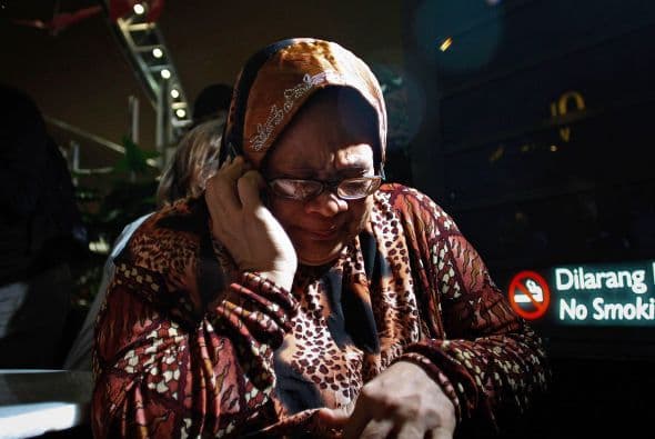 Familiares de los pasajeros del Malaysia Airlines vuelo MH17 lloran ante la tragedia.