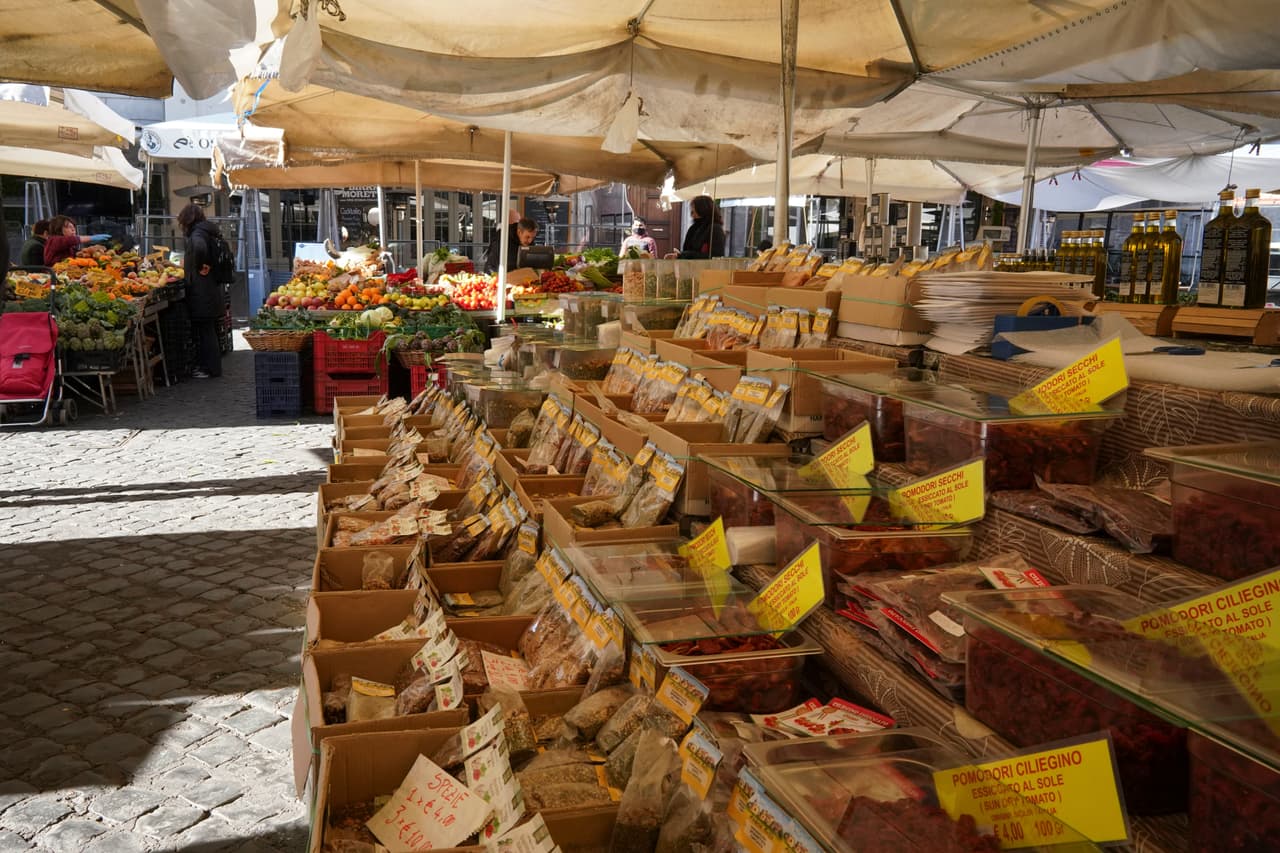 Pocas personas en el mercado al aire libre Campo dei Fiori, en Roma. El gobierno italiano asegura a sus ciudadanos que los supermercados permanecerán abiertos y abastecidos después de que estallaran las 'compras nerviosas'. "Me cancelaron todas las reservas hasta abril", cuenta Sara Matteuzzi, de 30 años, quien administra tres apartamentos en Roma. 
<b>"Quedé prácticamente desempleada", lamenta a la agencia AFP.</b>