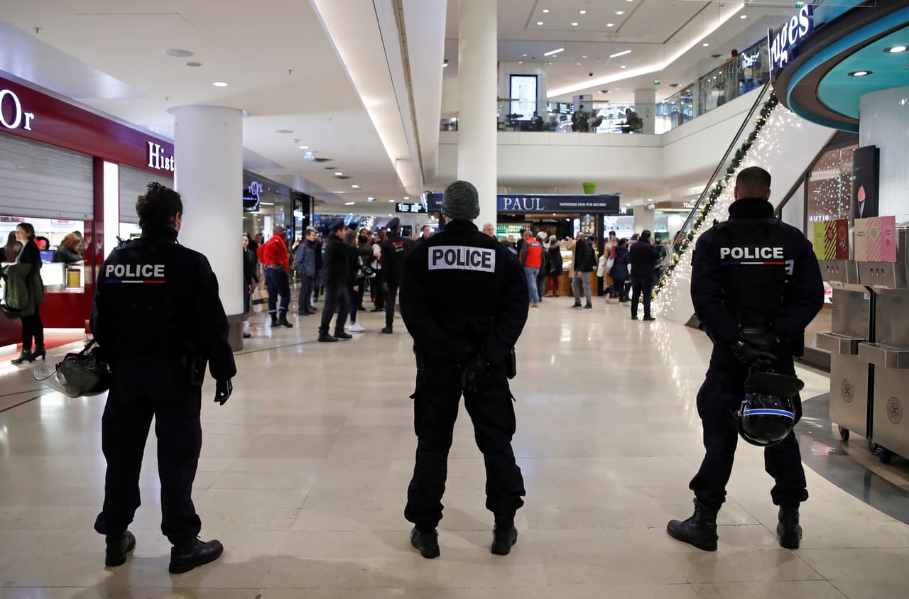 La policía francesa resguardando un pasillo del centro comercial Westfield Les 4 Temps mientras activistas de 
<i>Youth for Climate </i>protestan en contra del 'Viernes negro'. La manifestación fue criticada por el presidente de la Asociación de Ventas Online de Francia, Francois Momboisse, quien dijo al canal BMF TV que el "
<i>Black Friday</i> es uno de los días de mayores ventas del año".