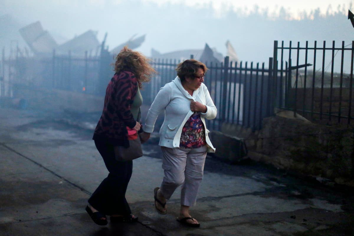 Decenas de personas con botellones o baldes sacaban agua de piscinas y la llevaban hasta viviendas humeantes, pero ya no había nada que hacer frente a un voraz incendio que comenzó como un siniestro forestal y se convirtió en uno estructural.