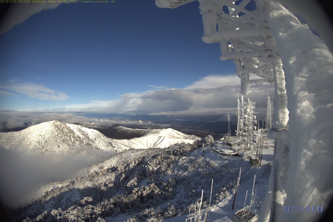 Esta es la visual de este jueves, en tiempo real, desde las cámaras de la Universidad de San Diego, en la cumbre de la montaña 
<b>Santiago Peak a una elevación de 5,700 pies de altura, muestran como la <a href="https://www.univision.com/local/los-angeles-kmex/tormenta-invernal-rompe-records-por-bajas-temperaturas-y-acumulados-de-agua-y-nieve-en-el-sur-de-california">tormenta invernal</a> congeló las antenas repetidoras en la zona sur del estado.</b>