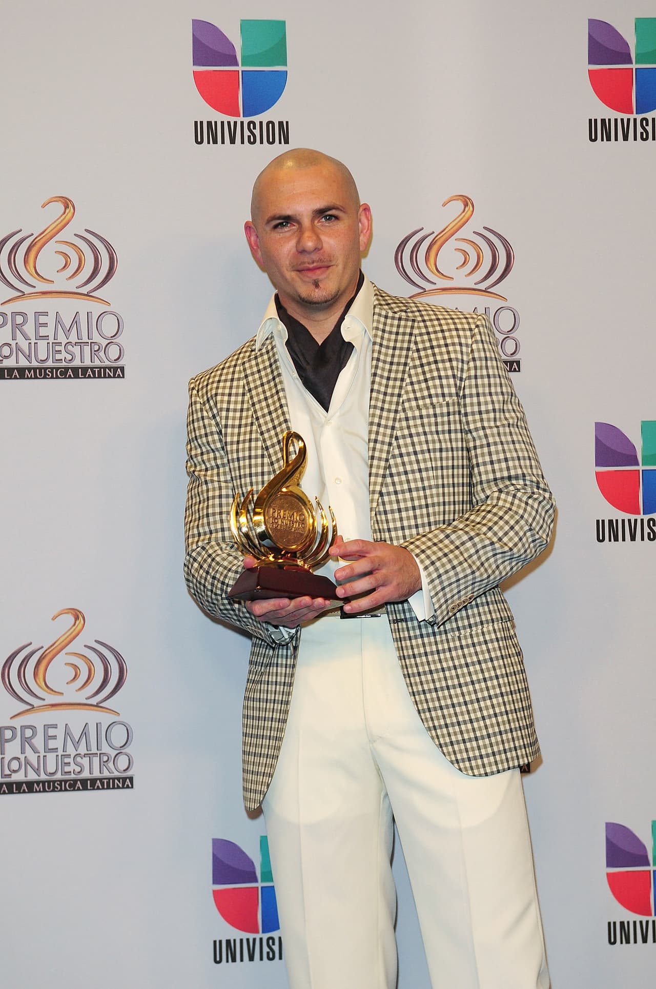 Pitbull sostiene el premio a Artista del Año en la categoría Urbano, categoría en la que compitió contra Daddy Yankee, Don Omar, Tony Dize y Wisin & Yandel.