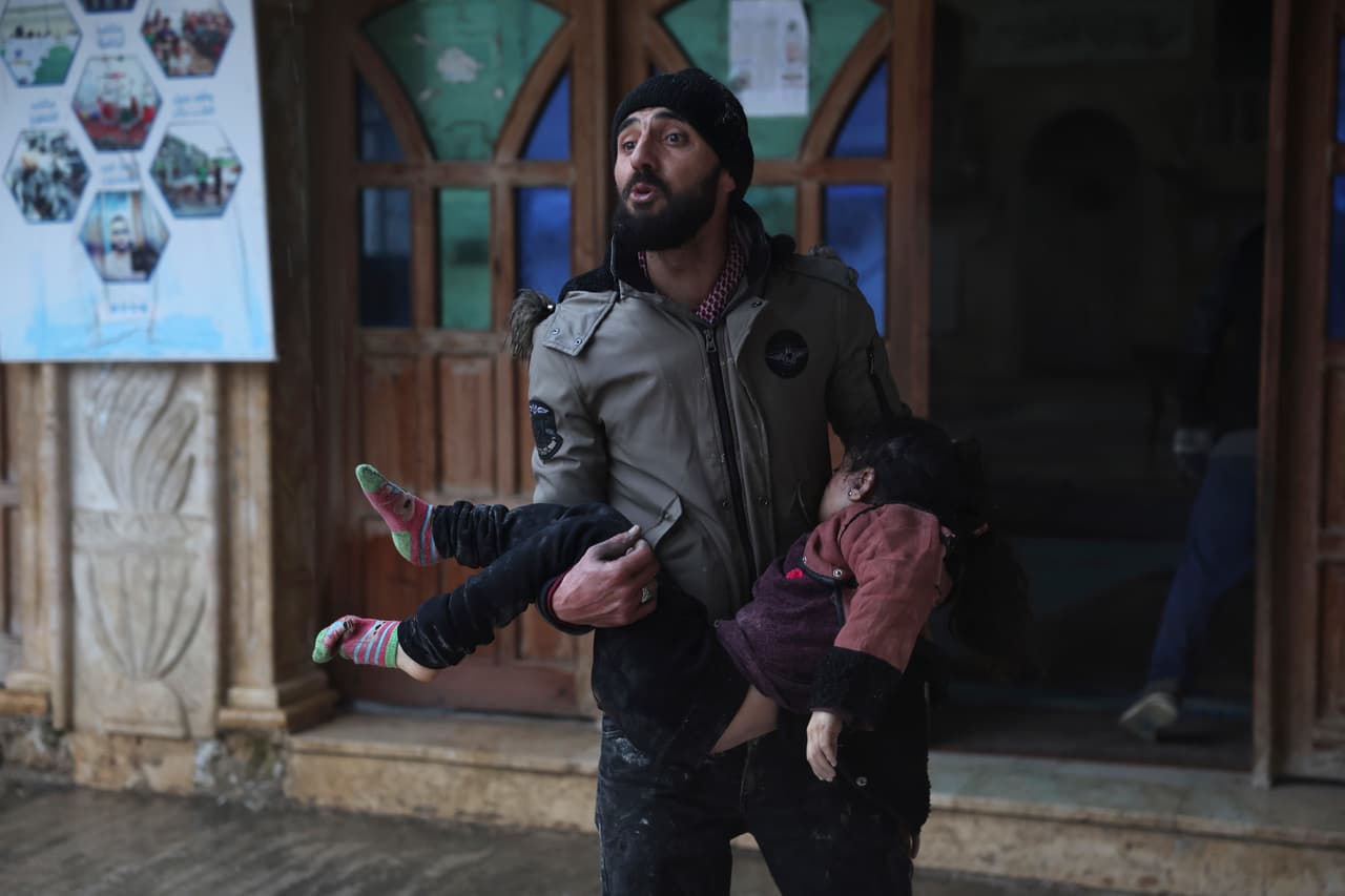 Un hombre sirio lleva a una niña muerta en la localidad de Azmarin, en la provincia de Idlib, en el norte de Siria.