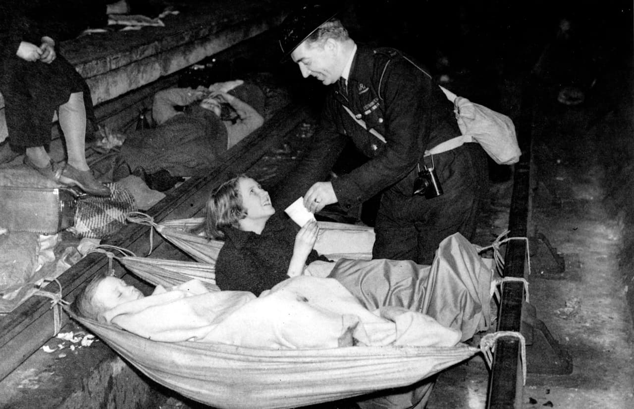Un militar asiste a una niña en la estación de Aldwych, en el metro de Londres, durante un bombardeo nazi.