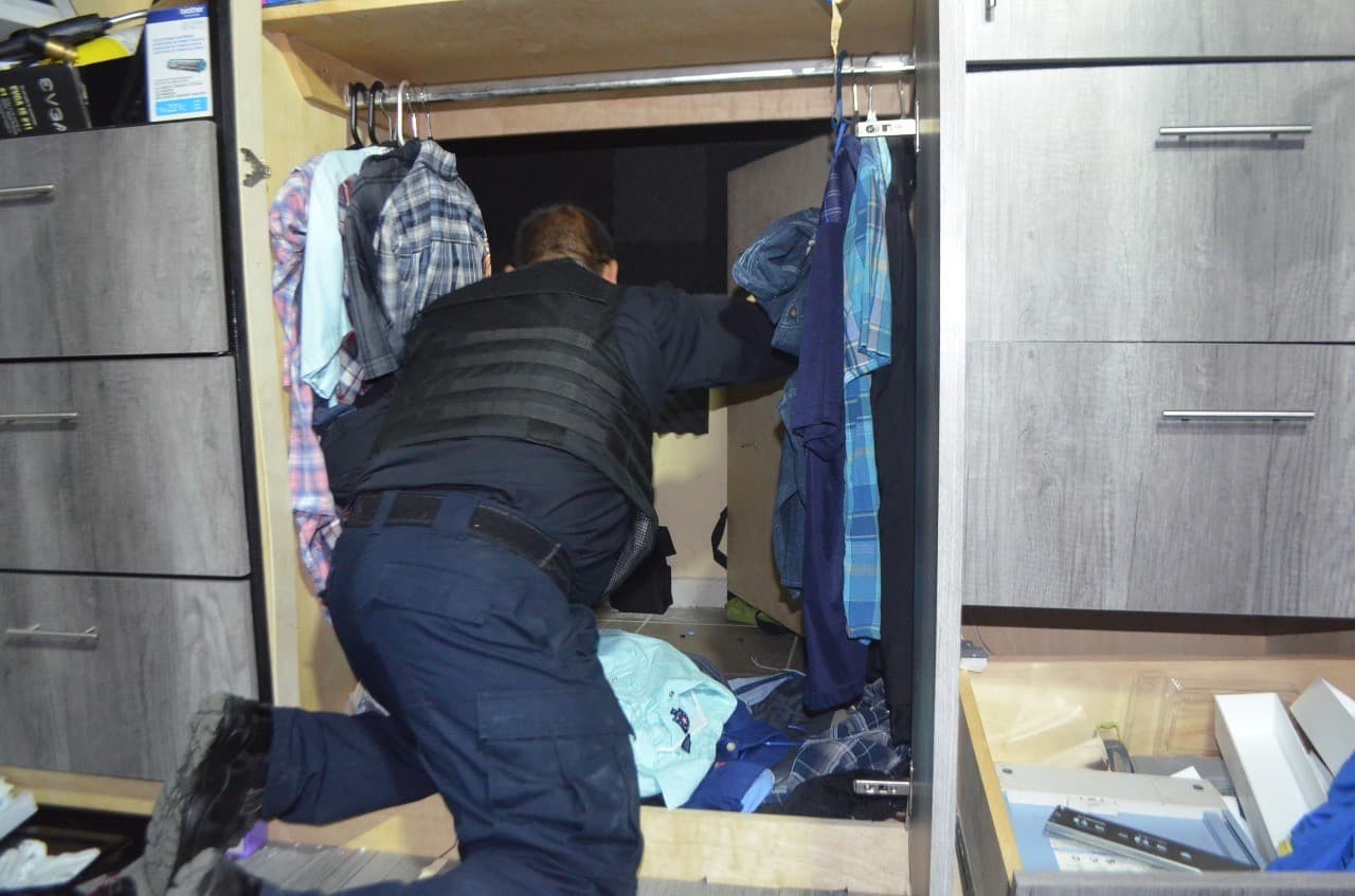 La Fiscalía de Baja California informó que la vivienda tenía una bodega secreta detrás de un clóset de madera, que se abría activando un botón oculto tras uno de los cajones.