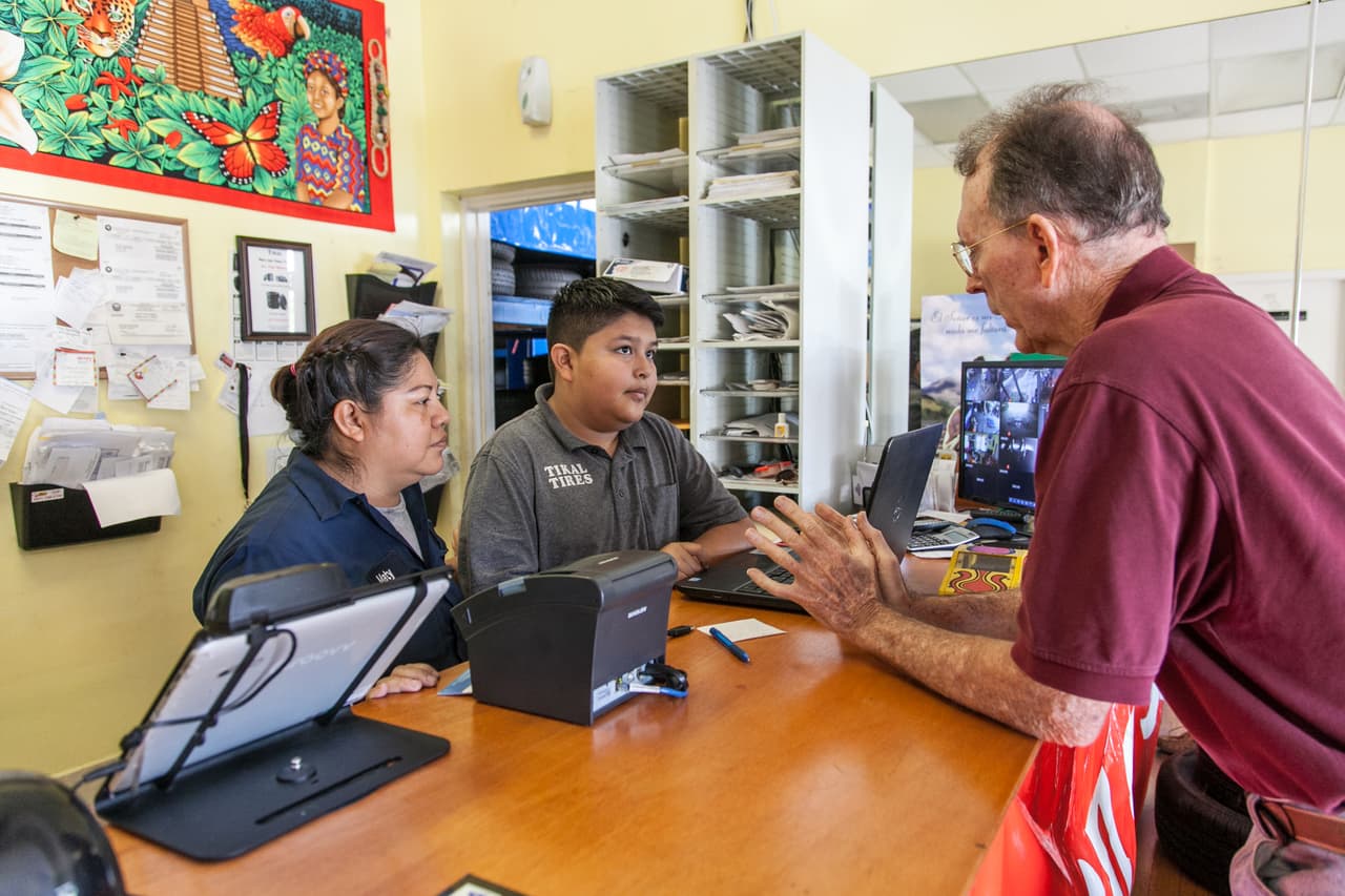 Pese a que según Maty, su esposo tiene actas de fallecimiento que muestran que el ejército mató a varios miembros de su familia durante la guerra, éste nunca pidió asilo. Llegó solo cuando tenía 14 años y se puso a trabajar en los campos de Immokalee (Florida) piscando tomates y cortando pepino. Después, se fue a una planta procesadora de pollos en Ohio. En la imagen, Jimmy ayuda a un cliente en la oficina del taller.