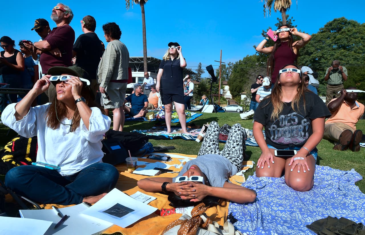 Sentados y acostados, así experimentaron las personas en Caltech, Pasadena, los cambios en el cielo mientras transcurría el eclipse parcial de sol.