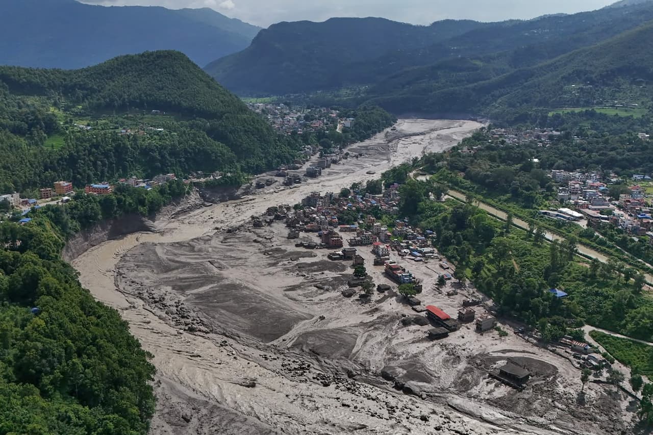 Casas dañadas permanecen en posición precaria cerca de las orillas desbordadas y obstruidas por escombros del río Trishuli, tras unas inundaciones repentinas en el distrito nepalí de Nuwakot el miércoles 26 de agosto de 2026.