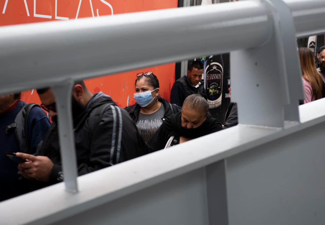 Una mujer con el rostro protegido por una mascarilla espera cruzar a los Estados Unidos desde Tijuana en el puerto de San Ysidro, antes de que entre en vigor el cierre.