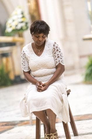 La catecúmena Judith Hercule-Daphinis espera el lavado de sus pies, que fue hecho por el monseñor Thomas Wenski.