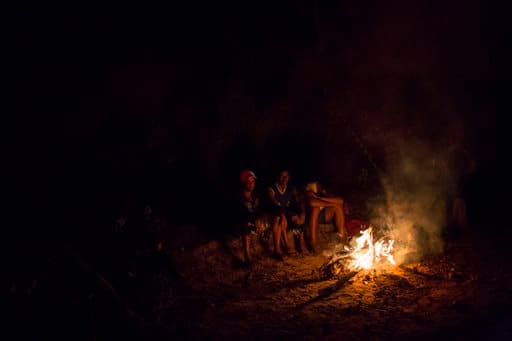 Un grupo de residentes se sientan en una hoguera después de evacuar sus casas en Bento Rodrigues.